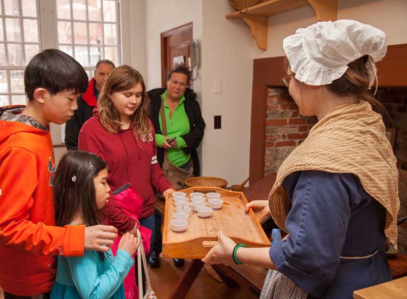 Lady offering tea to childrens