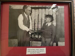 Photo of Charles Henry Jewell teaching a boy how to ring the chime bells at Old North Church during the 1930s.