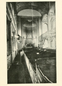 Image of the interior of Old North Church from "A Visit to the "Old North Church," Boston, Mass." by Charles Downer. The image displays rows of pews facing the altar at the front of the church.